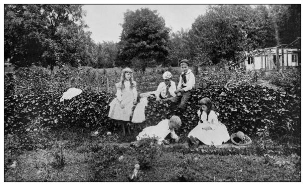istock Antique black and white photo: Children playing in rose garden 1261654783