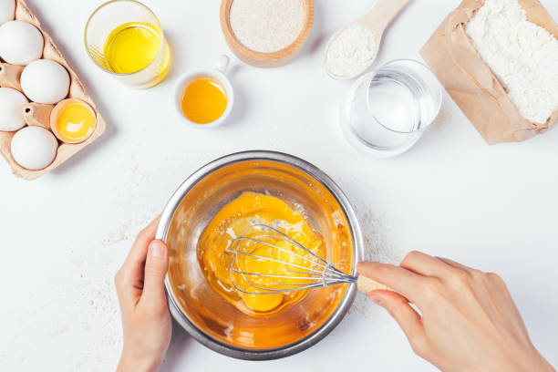istock Top view of female hands whisk eggs to make dough 1261656442