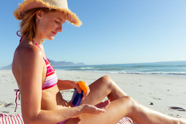istock Woman applying sunscreen at the beach 1261660587