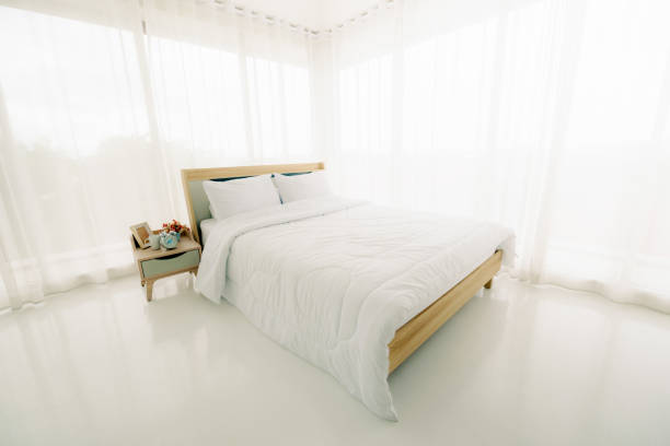 istock White minimalist bedroom interior at morning with sunlight. 1261661673
