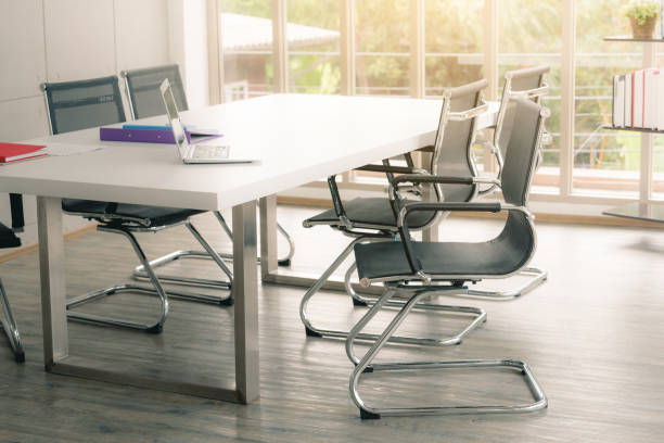 istock Black chairs in white conference room with sunlight. 1261662219