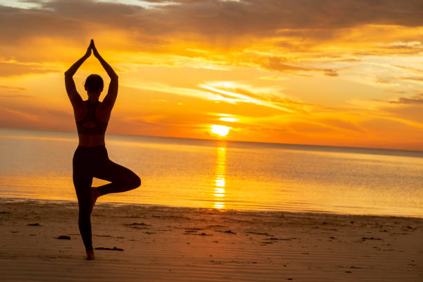 istock Woman doing yoga on the beach 1261664077