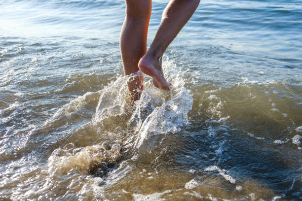 Woman's legs entering the sea on a beach