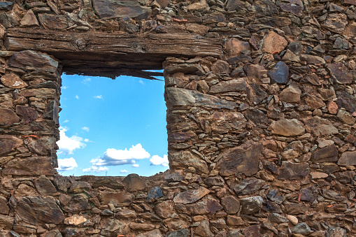 View from the old window - stone frame of landscape. Window in an old stone fortress. View from window to sea and sky. View through stone window in the wall castle.
