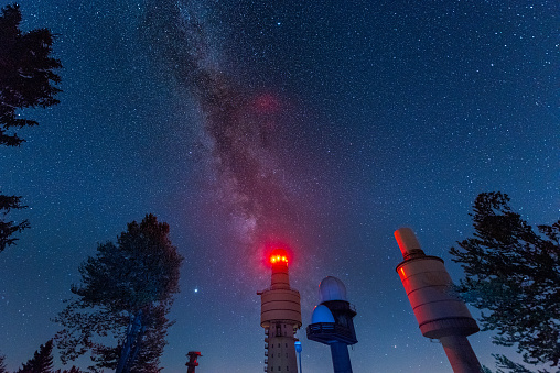 Radio and telecommunication towers of the former NATO listening post for the so-called Communication Sector F on the mountain Hohenbogen near Neukirchen in the Bavarian forest at night with stars and the milky way