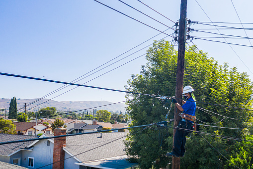 A technician working on the lines in a residential neighborhood