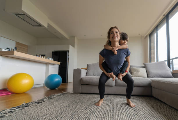 istock Woman exercising at home using her son as extra weight 1261687728