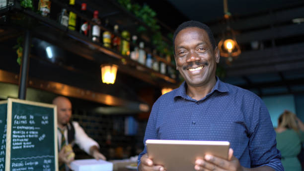 retrato de um garçom feliz usando tablet digital em um pub - homens de negócio - fotografias e filmes do acervo