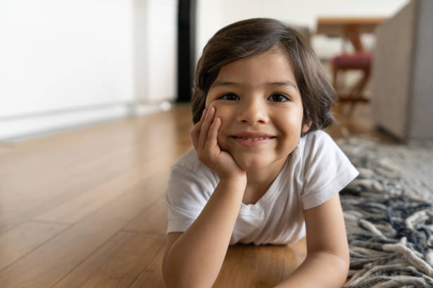 istock Happy boy at home lying on the floor smiling 1261688273