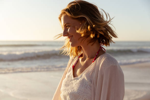 istock Beautiful woman smiling on the beach 1261690351