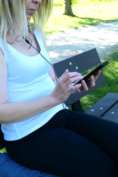 istock Girl in a park using a smartphone 1261692263