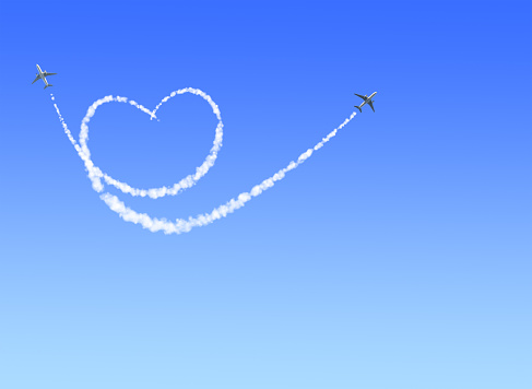 Two aircrafts draw a heart in the sky. Flight route of aircraft in shape of a heart. Love concept for traveling the world. Copy space for text