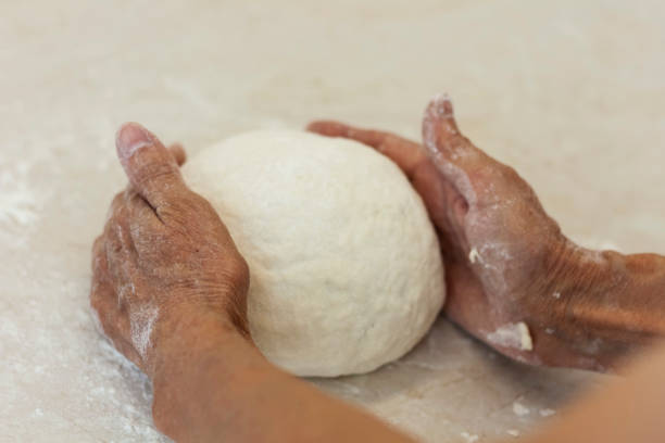 istock women's hands kneading making dough for dumplings. 1261717011