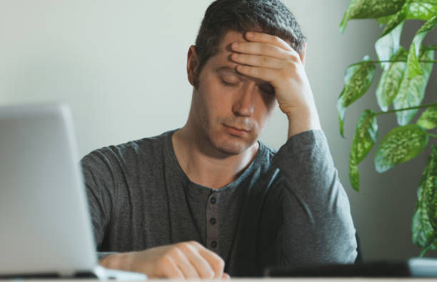 istock Tired exhausted man with headache in the office. 1261717095