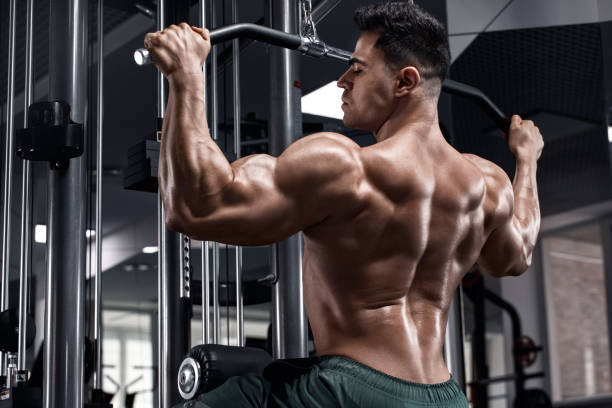 istock Muscular man workout in gym, doing exercise for back. Strong male rear view 1261718207