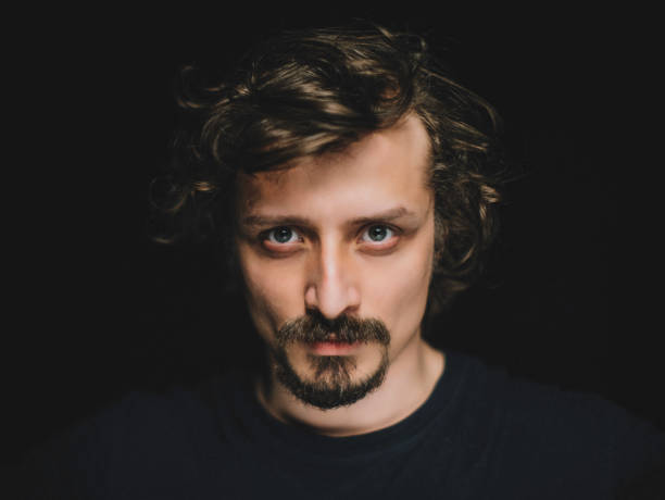 istock Portrait of Serious Man on Black Background 1261725019