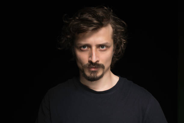 istock Portrait of Serious Man on Black Background 1261726705