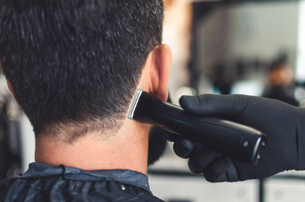 barbeiro cortou cabelo no pescoço e nuca de homem em barbearia com navalha elétrica profissional - nape - fotografias e filmes do acervo