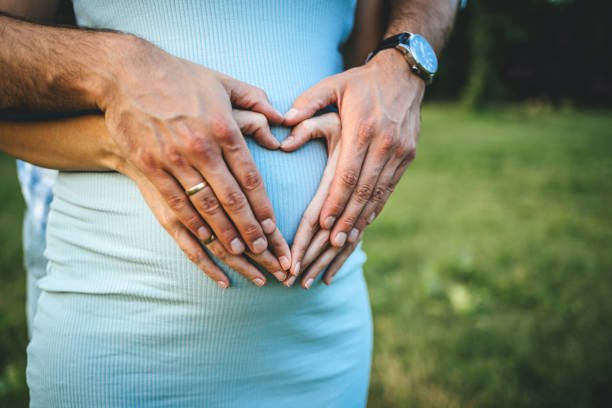 istock Future parents making heart shape on pregnant tummy 1261744317