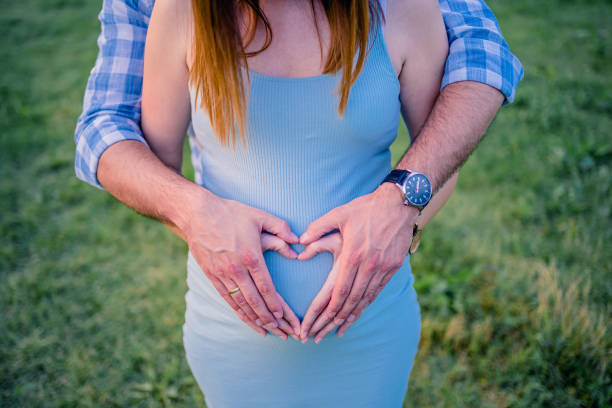 istock Future parents making heart shape on pregnant tummy 1261744451