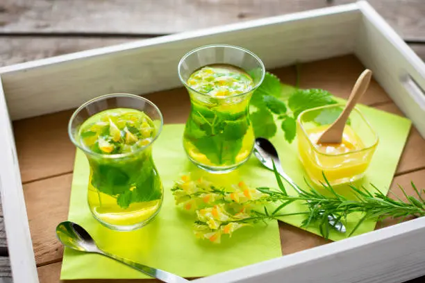 Photo of freshly brewed tea from lemon balm and linseed on a tray.