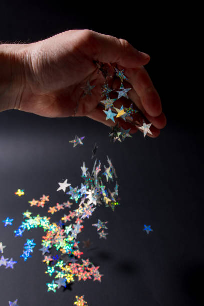 istock Man's hand sprinkles with magic stars 1261756289