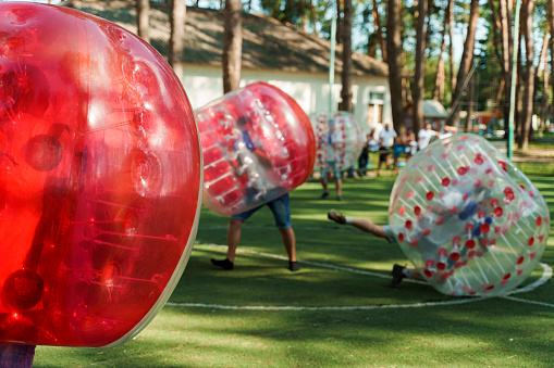 Juego de deportes de fútbol de burbujas. Los jugadores de fútbol juegan en el campo verde. Edificio de equipo. Hombre en globo de burbujas correr. photo