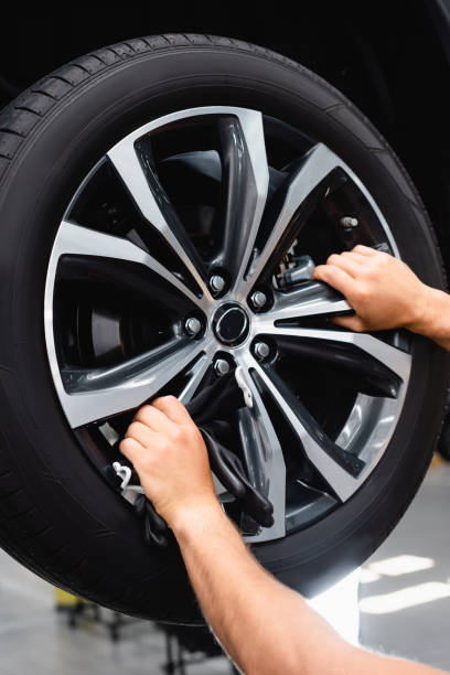 istock cropped view of technician touching wheel disk while fixing car 1261798595