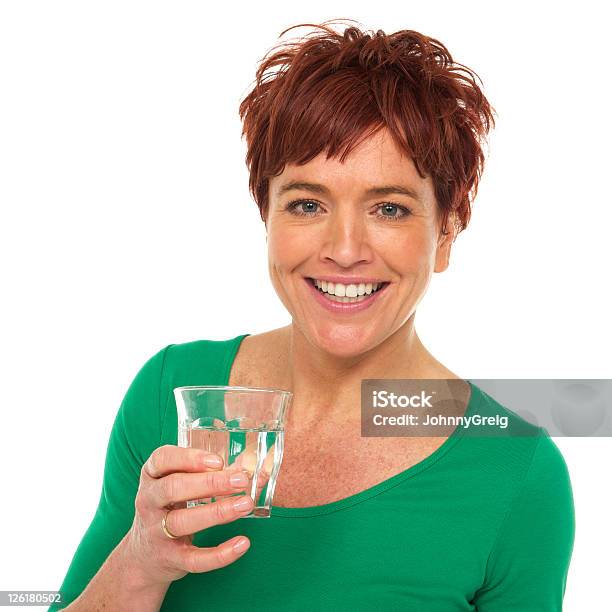 Mujer Sonriendo En Camisa Verde Cuenta Con Un Vaso De Agua Foto de stock y más banco de imágenes de 40-44 años