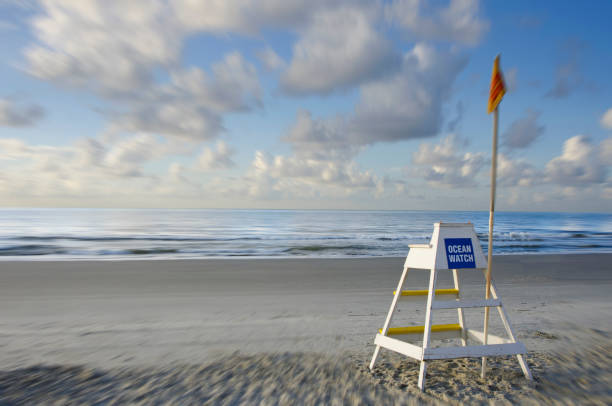 istock At the Beach: A Life guard stand sits empty with a yellow flag warning to swim with caution. 1261824707