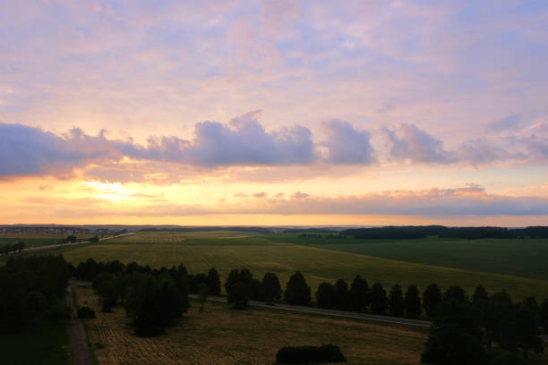istock summer sunset over the field and forest belt 1261825766