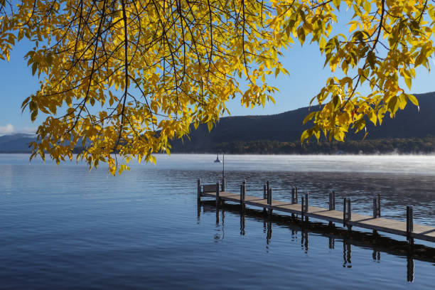 fischerbecken am see george im herbst - adirondack chair stock-fotos und bilder