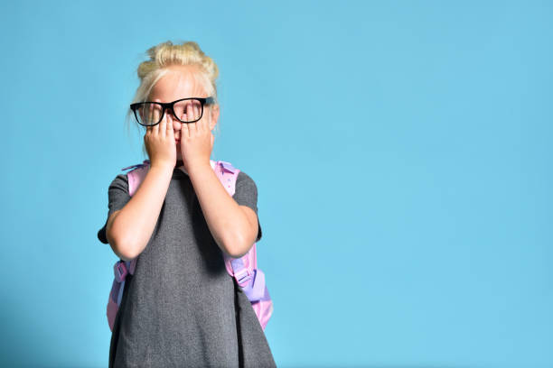 istock Young schoolgirl rubs her eyes from overwork 1261854053