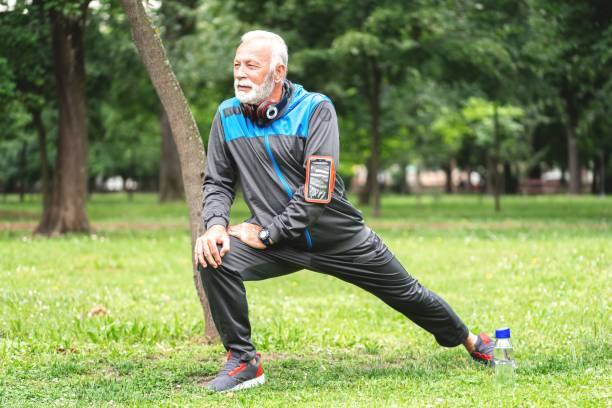 istock Senior sportsman doing stretching exercise at park 1261862624