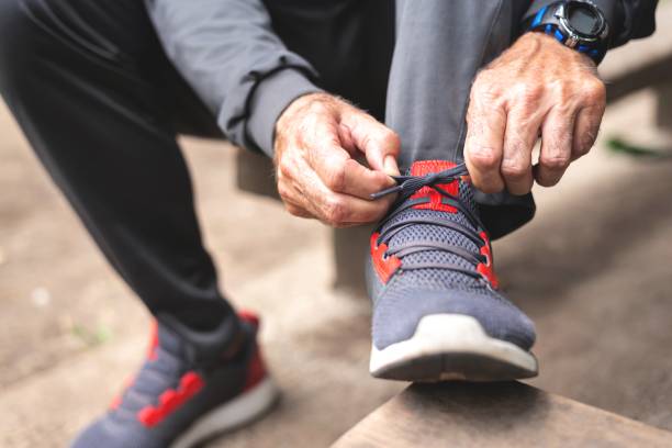 istock Senior man tying shoelace getting ready for workout 1261863149