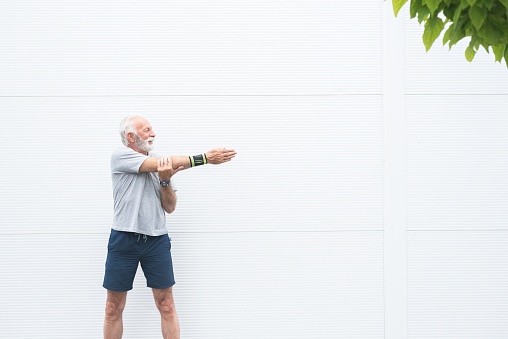 Senior sportsman doing stretching exercise