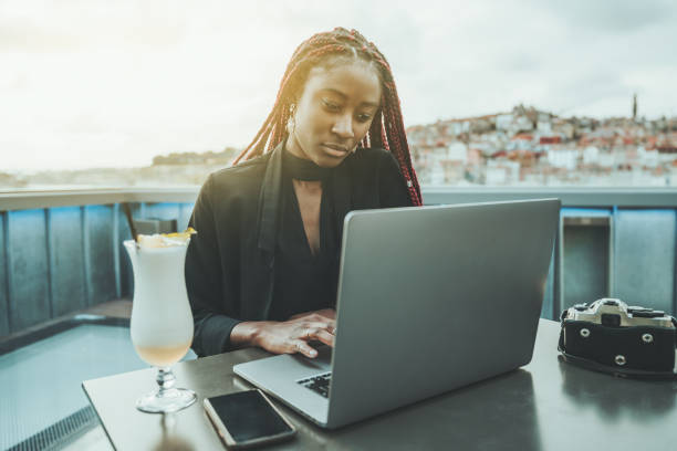 屋外のラップトップを持つアフリカの女性 - braids african descent women pensive ストックフォトと画像