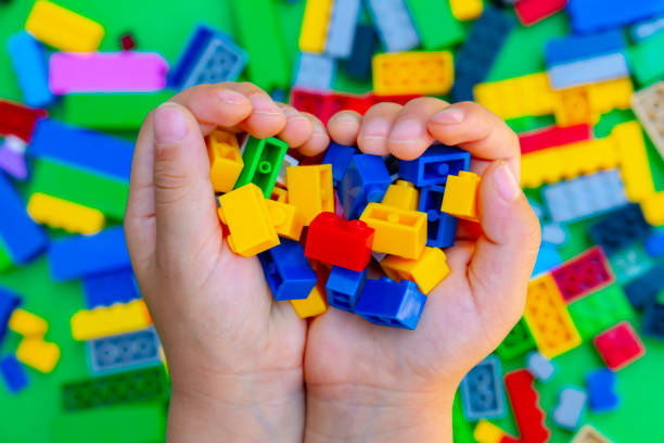 istock A kid holding small pieces of interlocking plastic colorful bricks toy. 1261878197