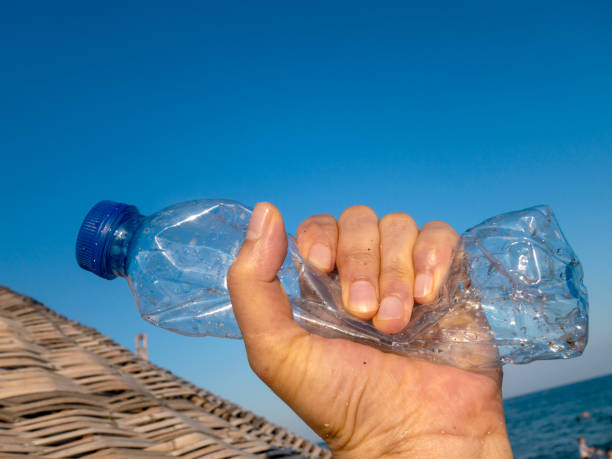istock Beach plastic bottle is holding in female hand 1261901296