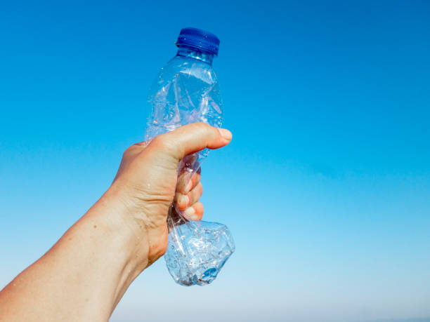 istock Beach plastic bottle is holding in female hand 1261906549