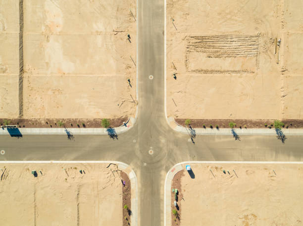 road intersection on graded land waiting for home construction - land development aerial view planning imagens e fotografias de stock