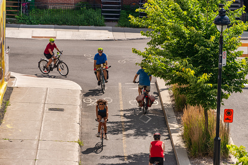 Montreal, Canada - 28 July 2020: People riding bikes on a cycle path, on Arcade street
