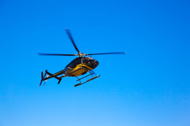 istock The isolated black yellow helicopter flying in the sky. 1261978571