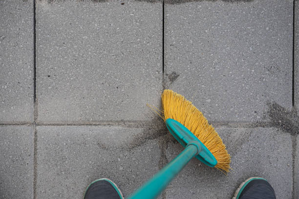istock Sweeping Jointing Sand in Paver Patio Installation 1261989501