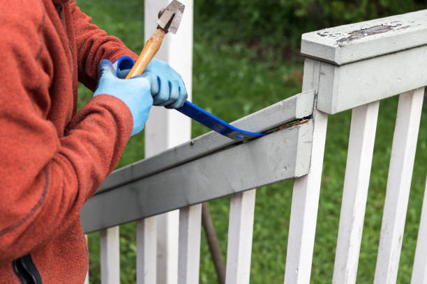 istock Man Using a Hammer and Pry Bar to Tear Down Old Deck 1261990557