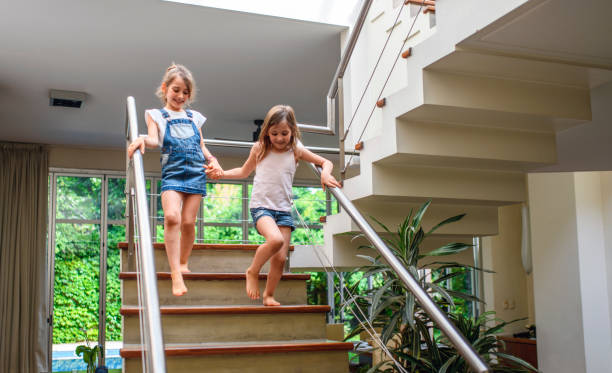 istock Happy Young Sisters Holding Hands and Descending Staircase 1262024662