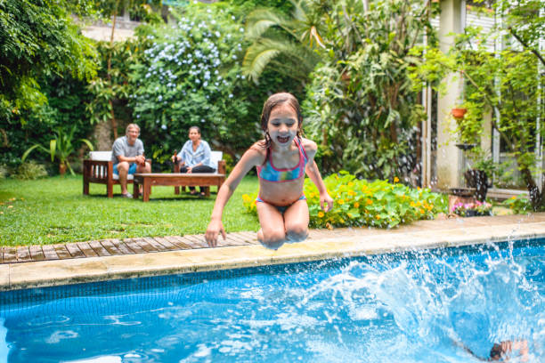 istock Young Girl Jumping Into Swimming Pool 1262024712