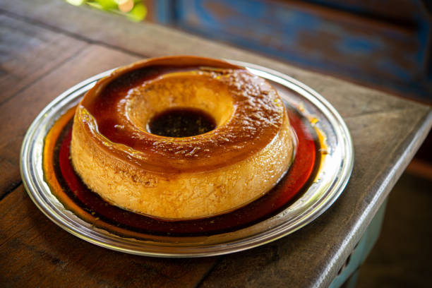 istock Brazilian gastronomy. Milk pudding with caramelized syrup on wooden table. 1262026175