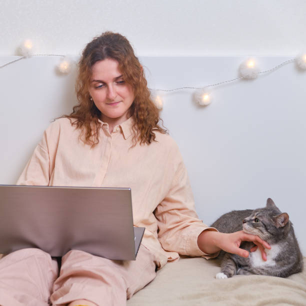 istock Girl hugging a cat during online education from home, close up 1262026351