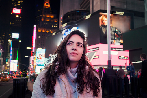 Brazilian young woman traveling in USA. Girl enjoying her time at Times Square in Manhattan, near Brodway. Famous place. Travel destination.